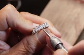 Hands finishing a diamond ring